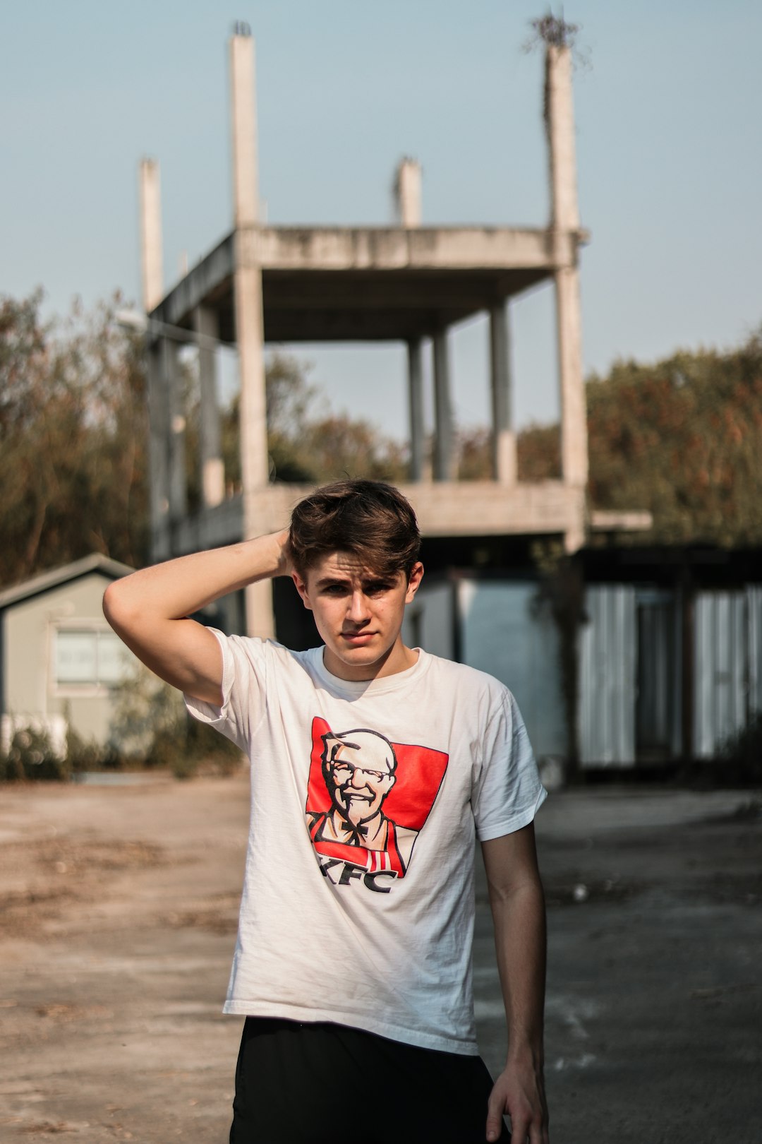 man in white crew neck t-shirt standing on brown soil during daytime