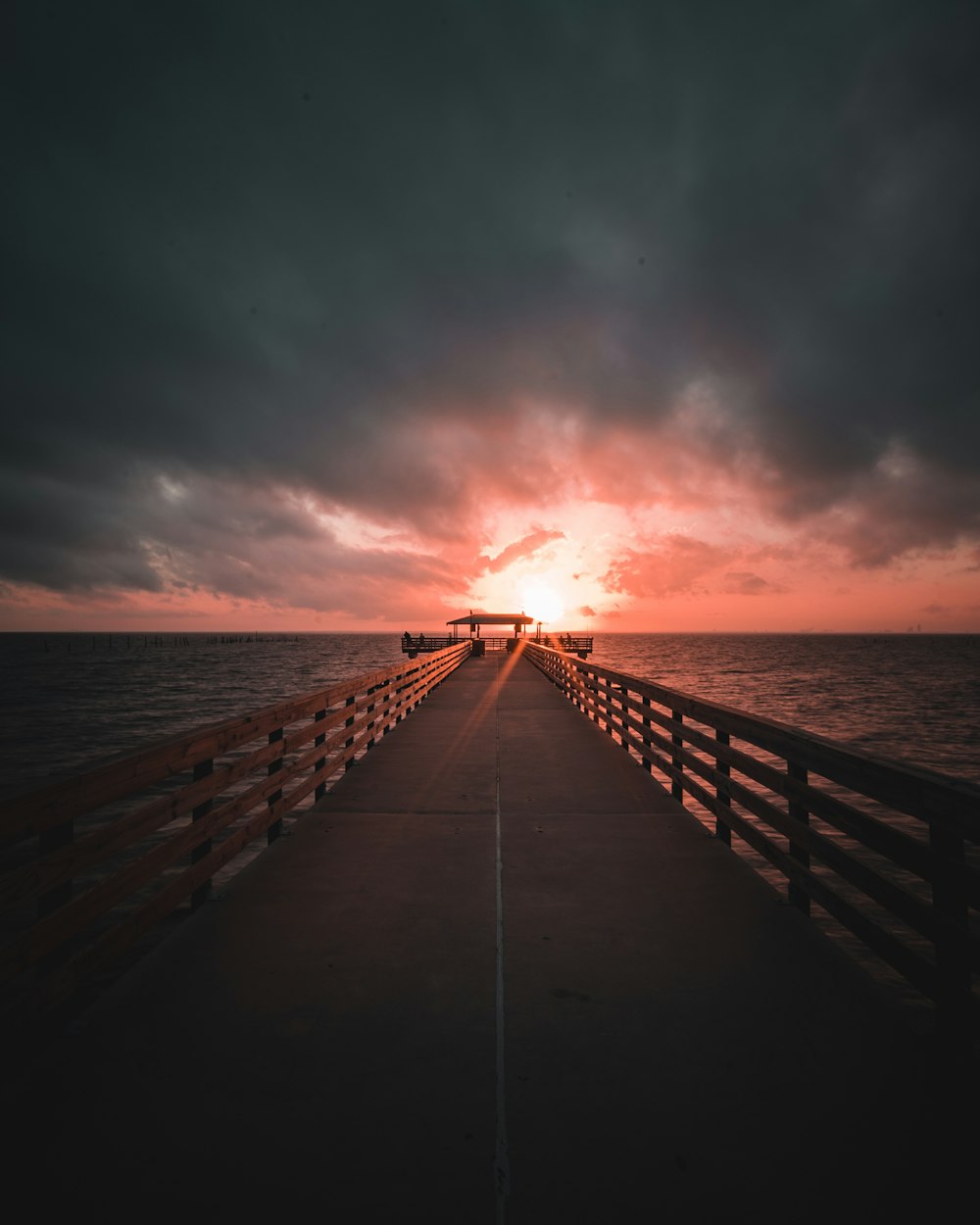 Quai en bois brun sur la mer au coucher du soleil