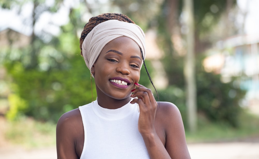 smiling girl in white tank top wearing white knit cap