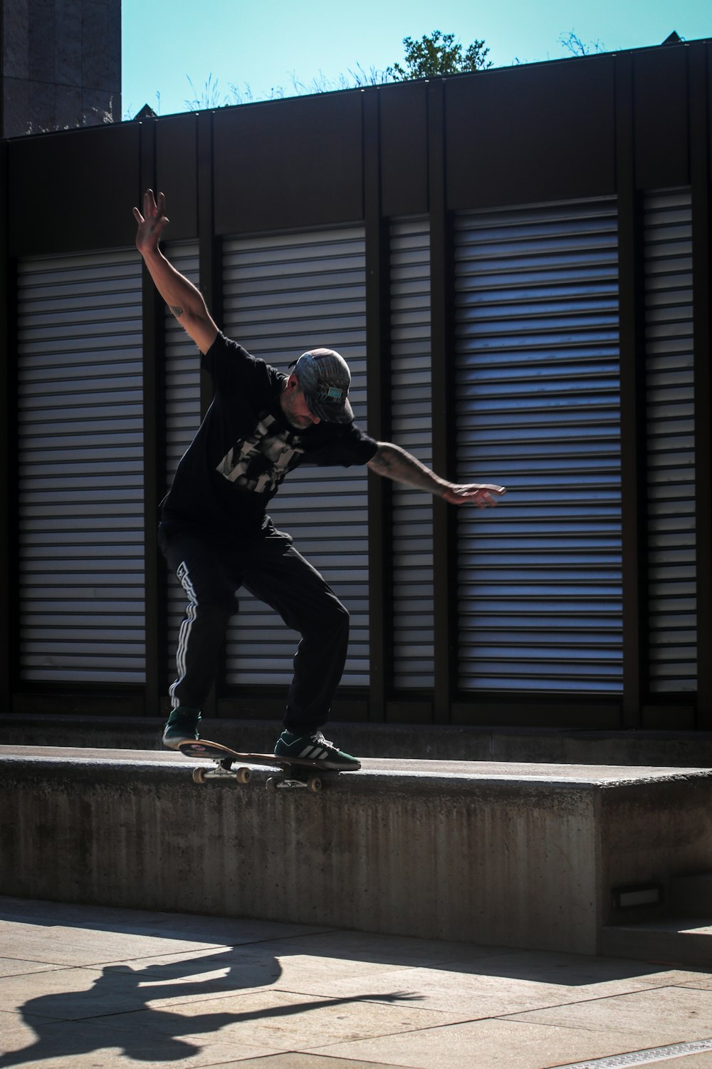 man in black t-shirt and black pants doing skateboard stunts