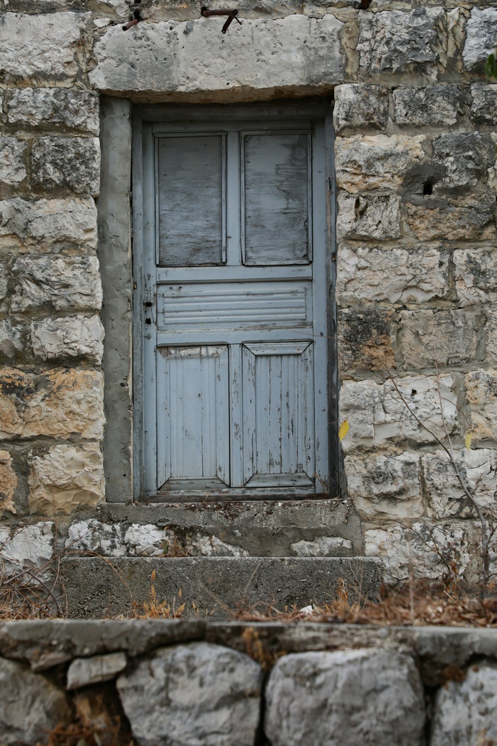 blue wooden door on gray concrete wall