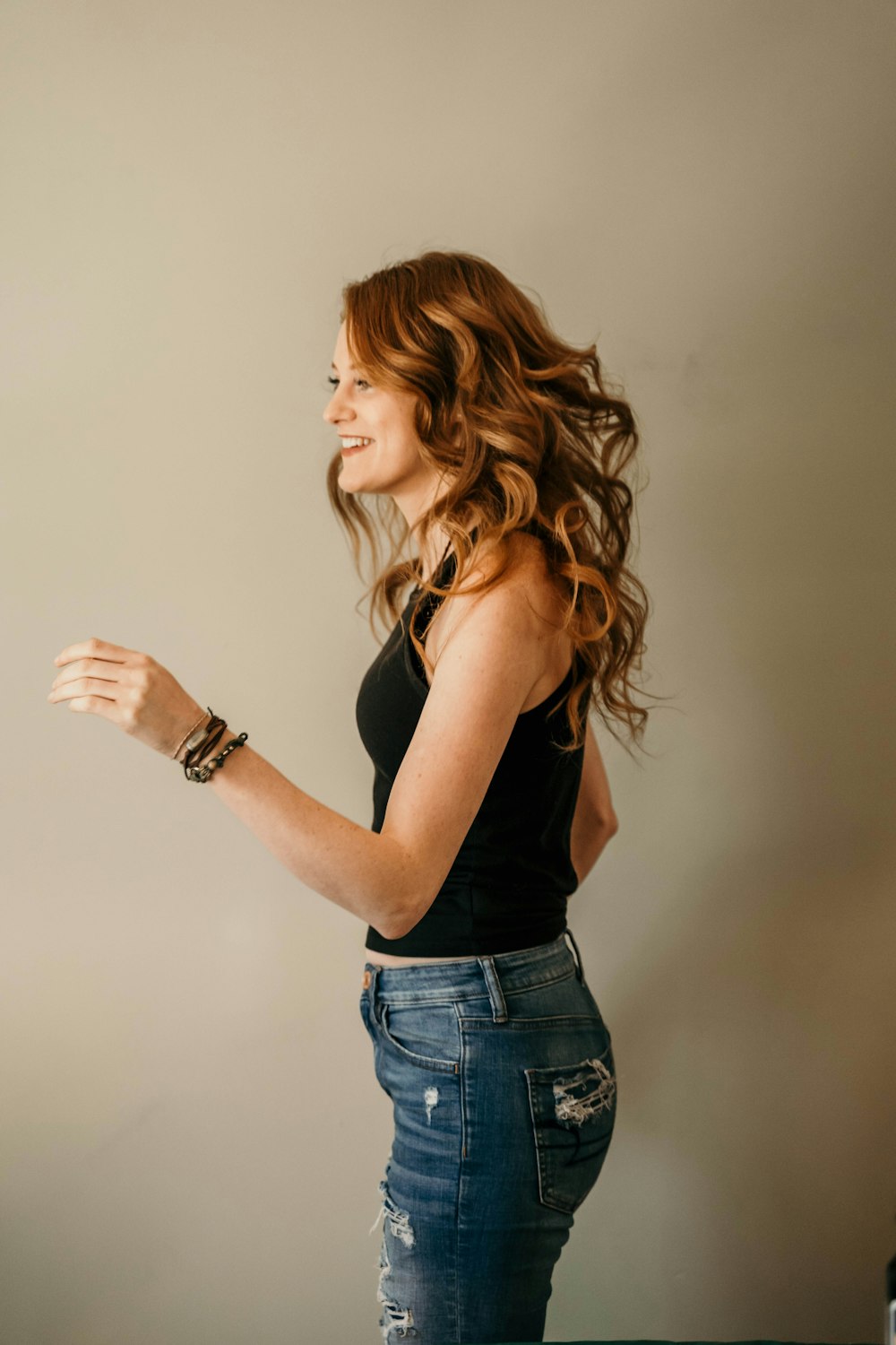 woman in black tank top and blue denim jeans