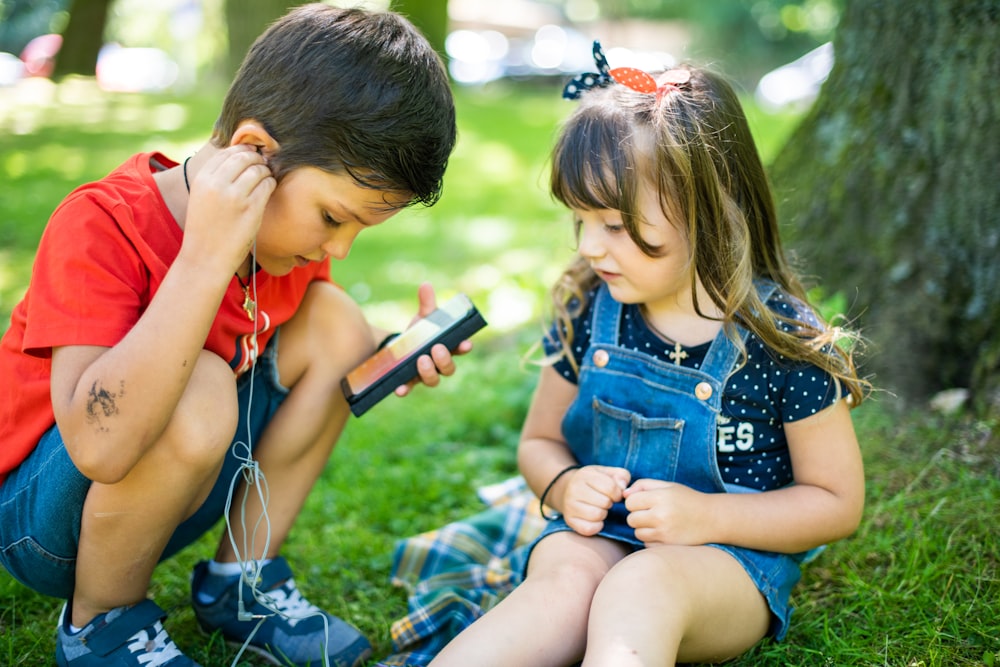 girl in blue denim button up vest holding smartphone