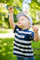 A joyful child stretching outdoors in a sunlit park, embodying healthy growth.
