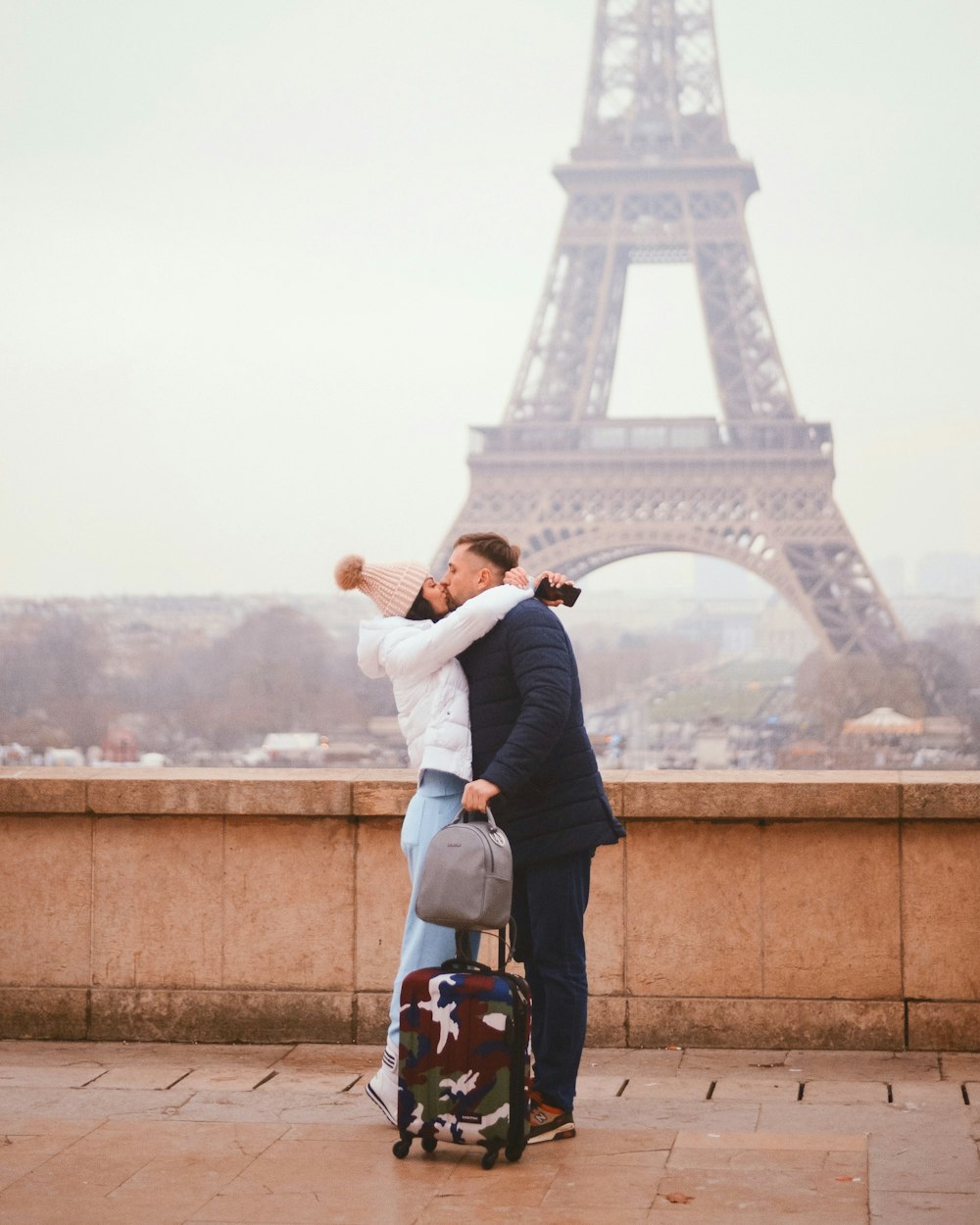 man in black jacket carrying woman in white long sleeve shirt