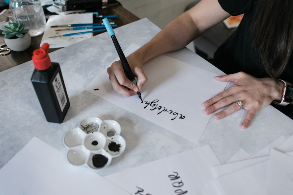 person writing on white printer paper