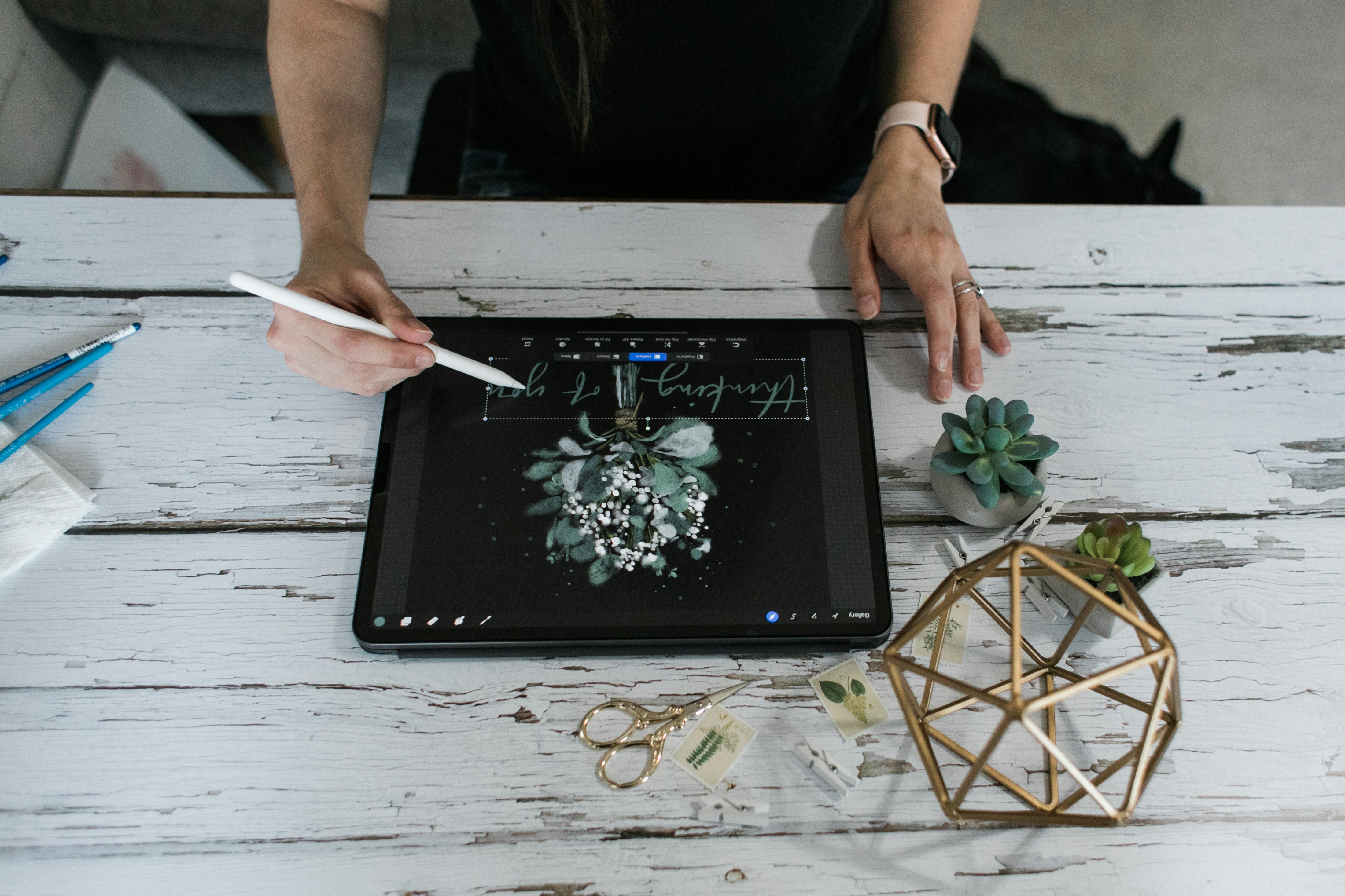 person holding white pen on black tablet computer