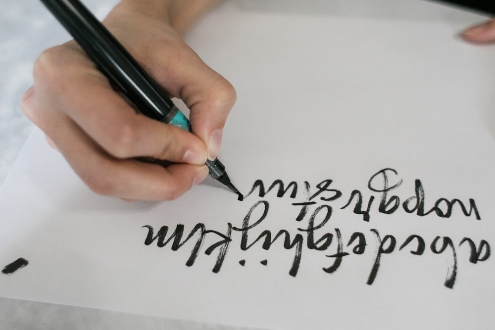 person writing on white paper