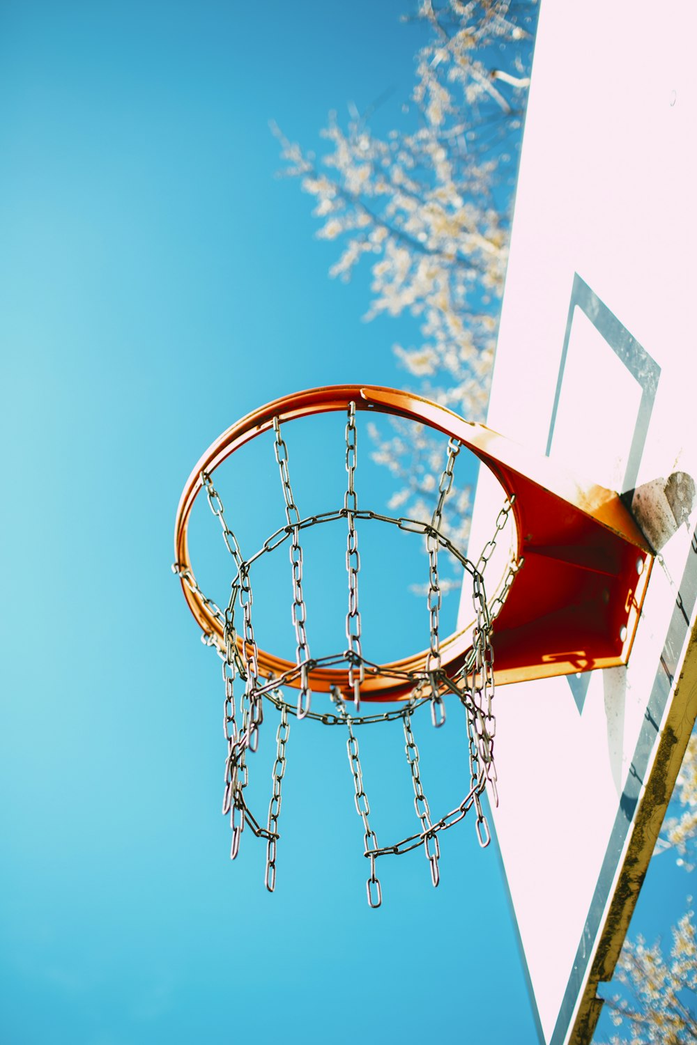 red and white basketball hoop under blue sky during daytime