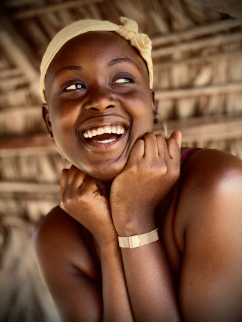 Close-up of a smiling traveler beside a traditional Moroccan village house.