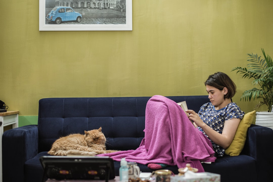 woman in black and white shirt sitting on purple couch