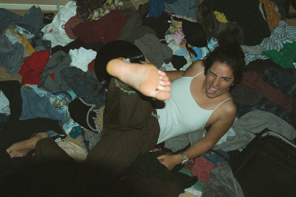 woman in white tank top and black pants sitting on bed