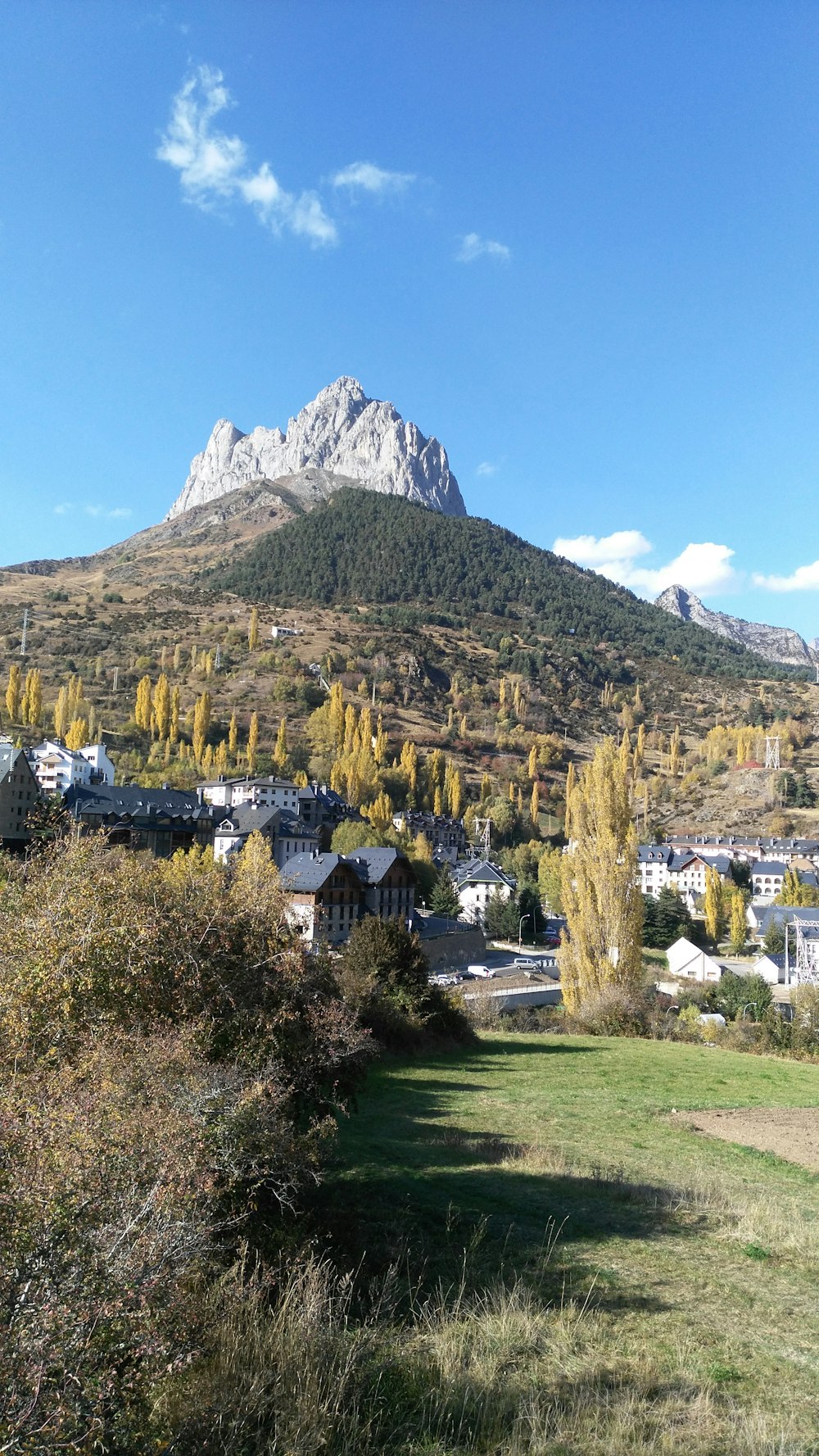 white and brown concrete houses near mountain under blue sky during daytime