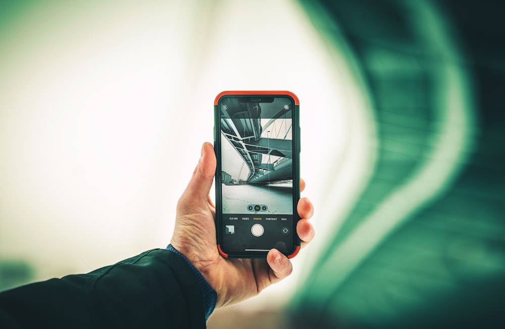 Persona sosteniendo un iPhone 6 con funda naranja