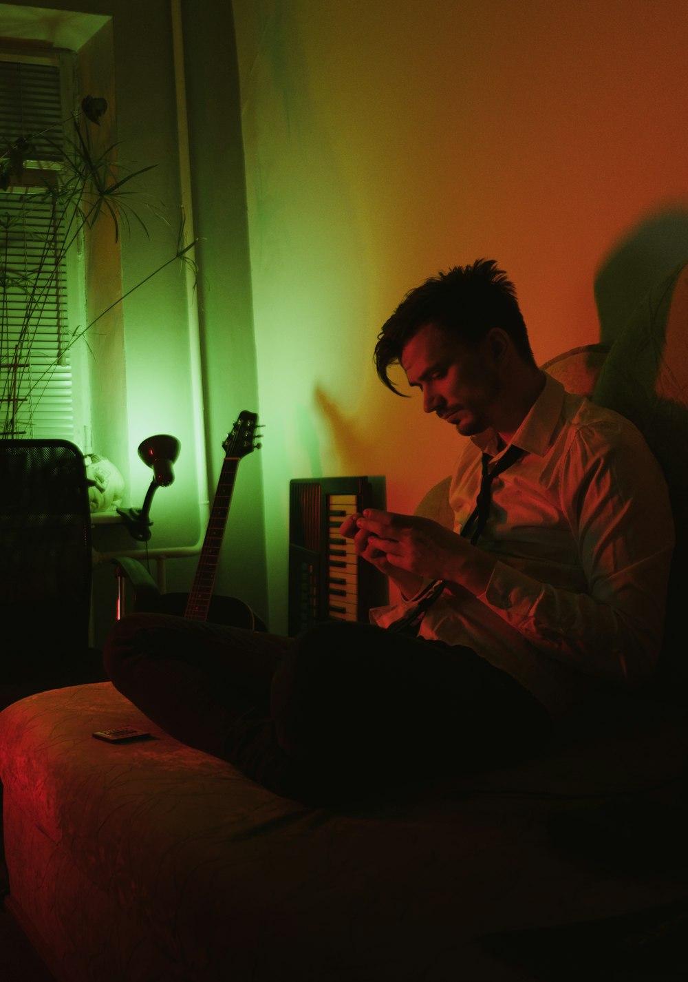 man in gray dress shirt playing electric guitar