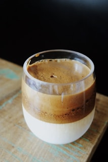 brown and white ceramic mug on brown wooden table