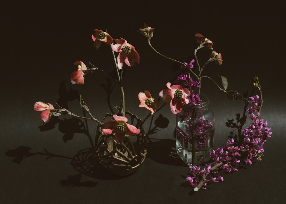 red and pink roses in clear glass vase