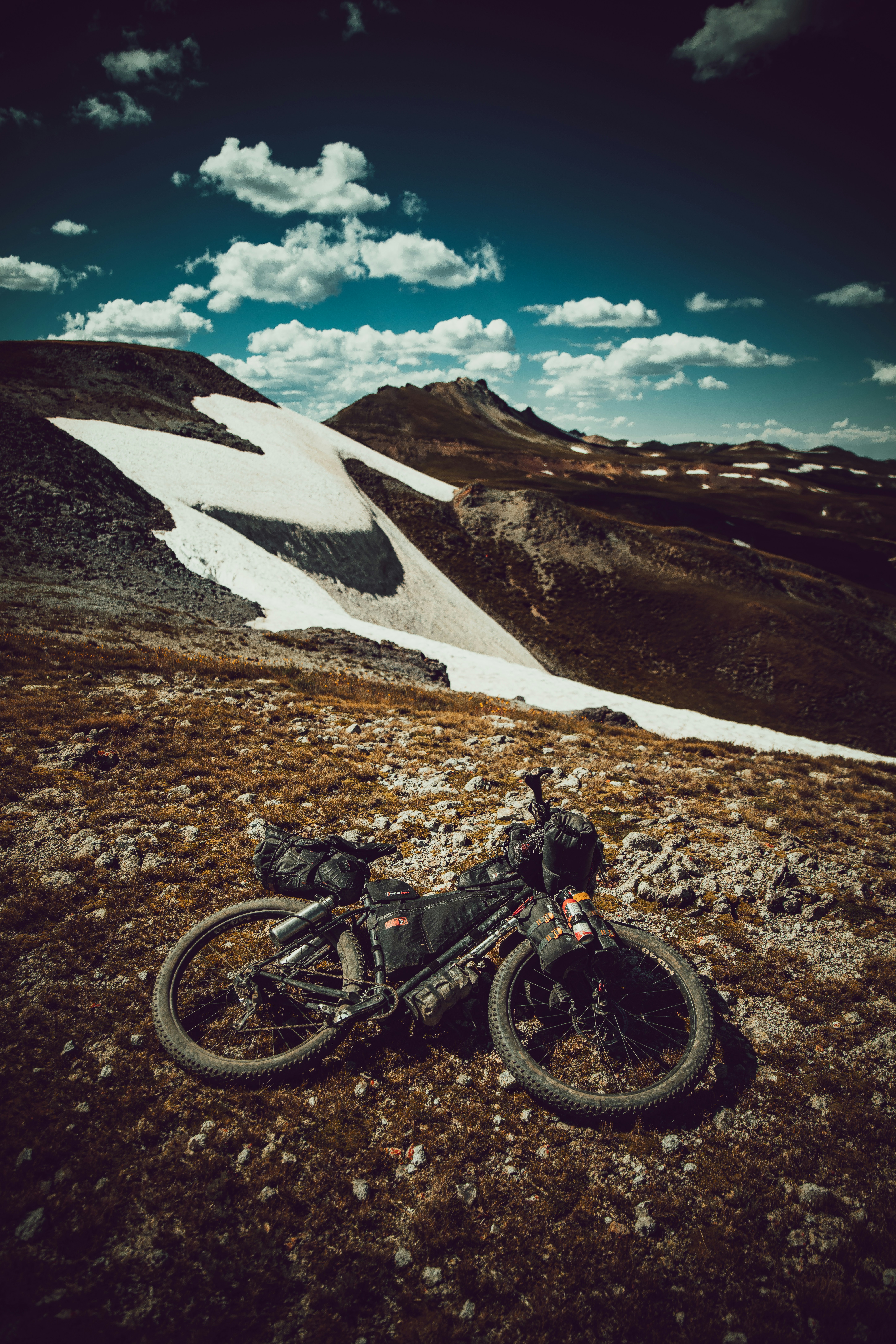 man riding motocross dirt bike on snow covered mountain during daytime