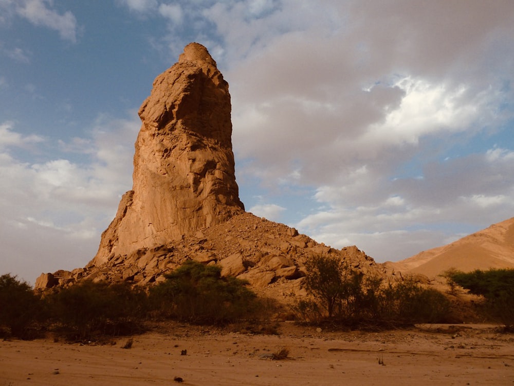 brown rock formation under white clouds and blue sky during daytime