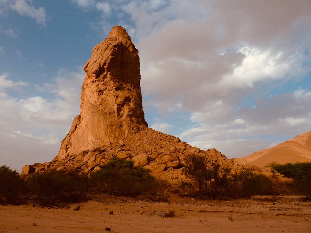brown rock formation under white clouds and blue sky during daytime