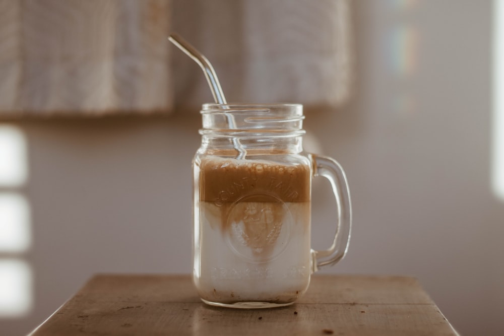 clear glass mug with brown liquid