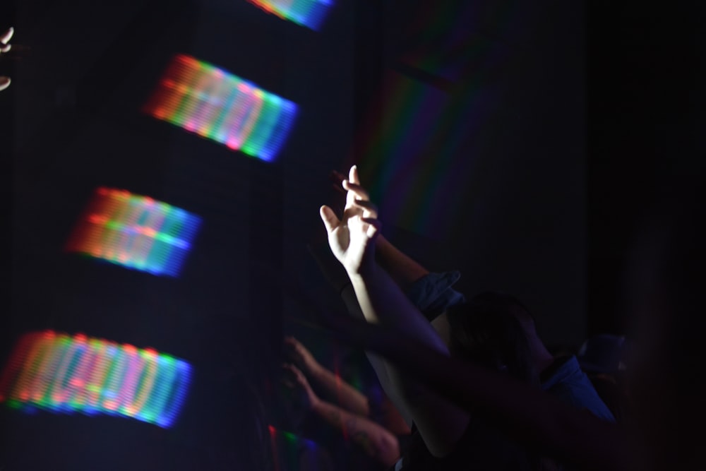 person holding smartphone in front of purple and pink light