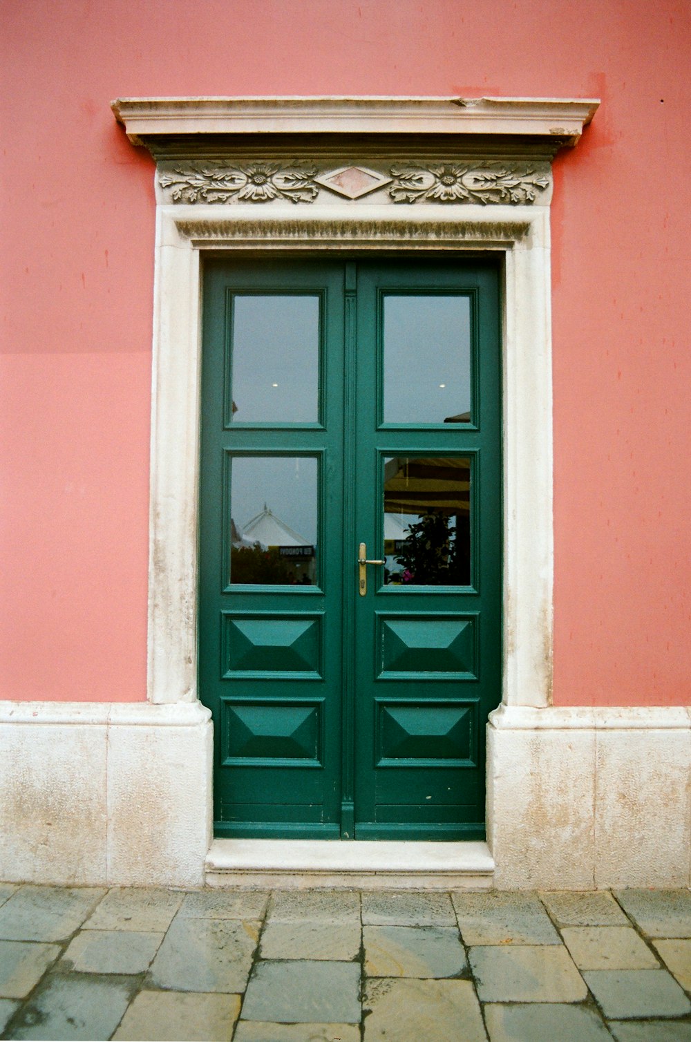 teal wooden door with white steel window frame