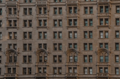 Elegant apartment building with large windows and earthy stone facade.