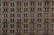 A facade of a classic architectural building with multiple evenly spaced windows and ornate decorative details. The stone exterior exudes an historic and elegant appearance.