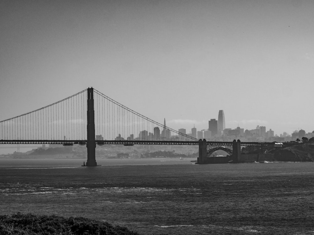 grayscale photo of bridge over body of water