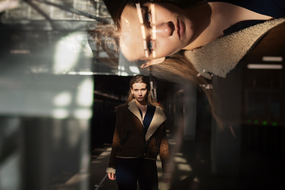 woman in black blazer standing near glass window