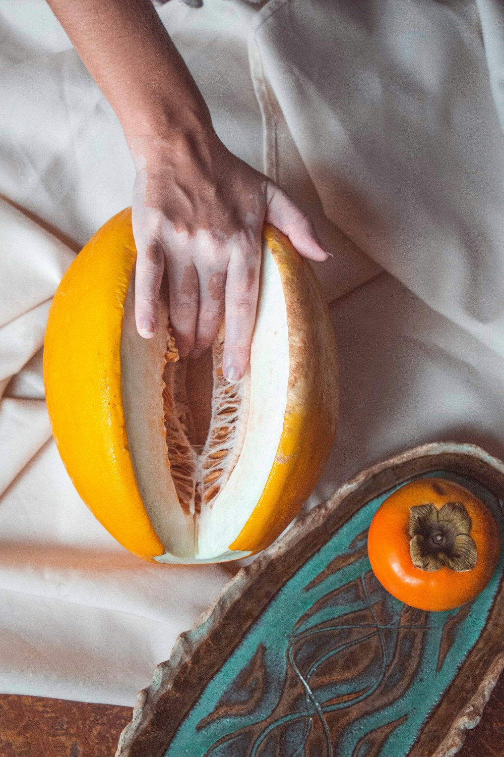 person holding sliced of yellow and brown fruit
