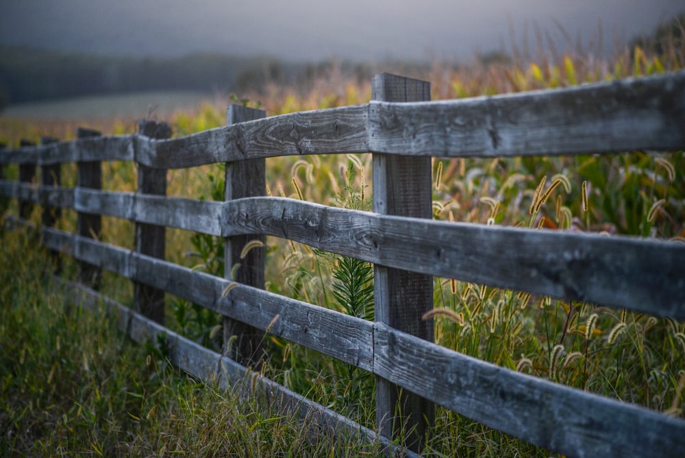 brown wooden fence on green grass field during daytime