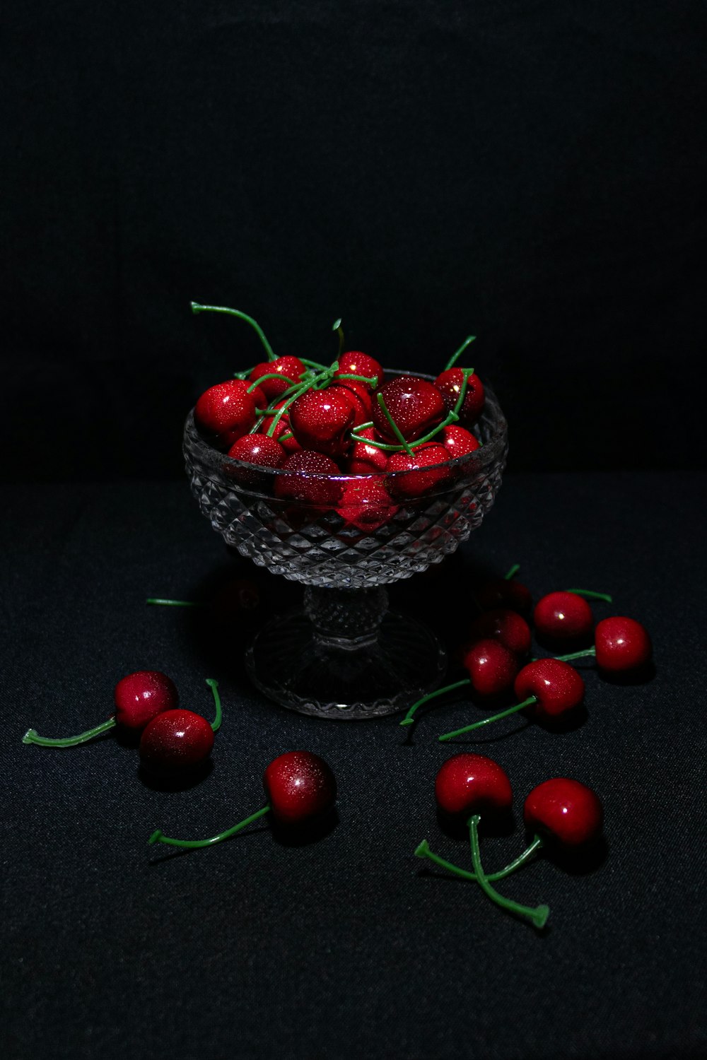 red cherries on clear cut glass bowl