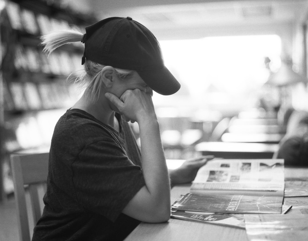 woman in black shirt wearing black hat sitting by the table