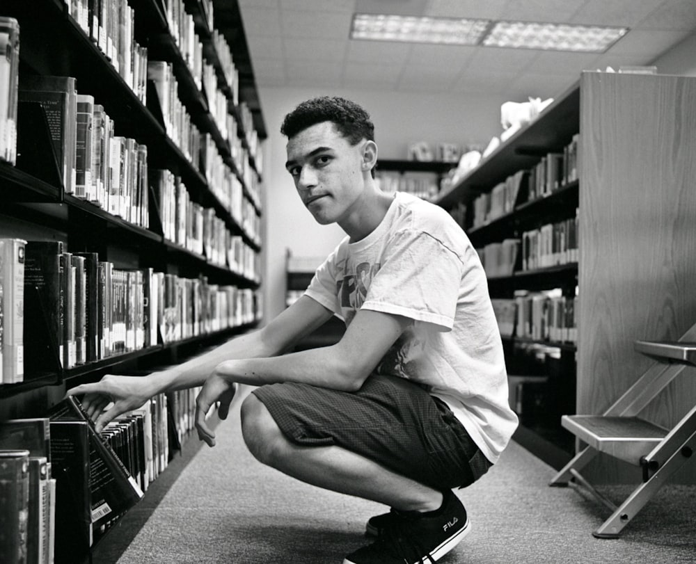 man in white crew neck t-shirt sitting on floor