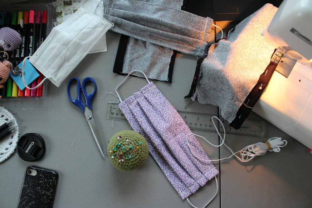 blue handled scissors beside gray and white towel