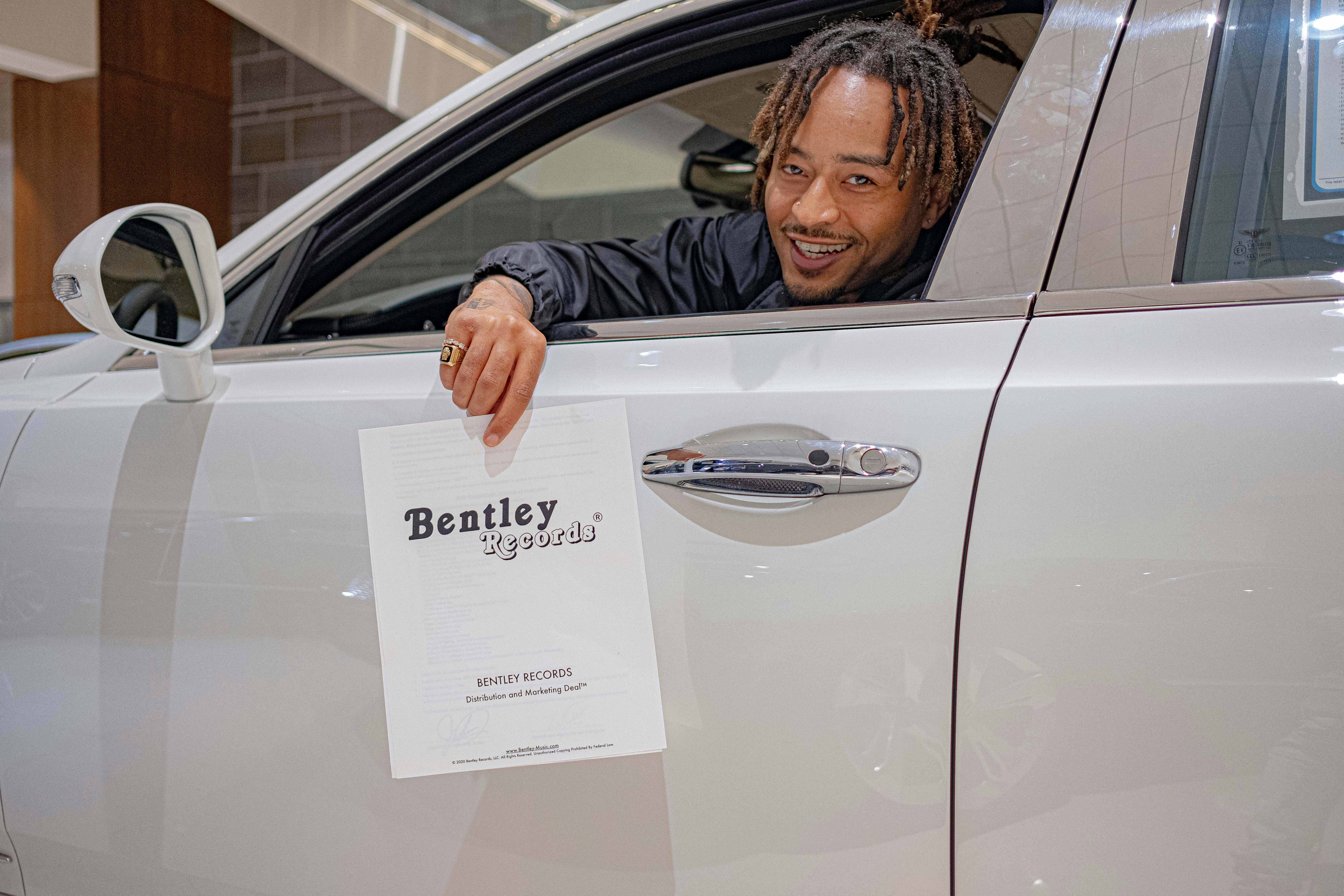 man in black jacket holding white paper