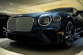 A luxury car is displayed in a showroom with a sleek design and glossy finish. The front grille is prominent, with intricate mesh detailing and chrome accents. The headlights are modern and stylish, and the car's body reflects the showroom lights, adding to its elegance.