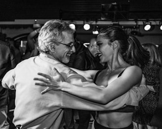 A joyful couple dancing at their reception, surrounded by friends and family celebrating.