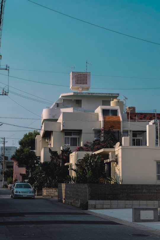 white concrete building near green trees during daytime in Okinawa Japan