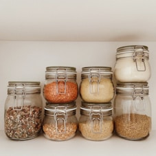 three clear glass jars with brown and white stones