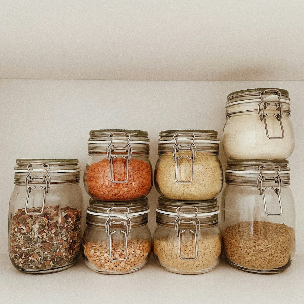 three clear glass jars with brown and white stones
