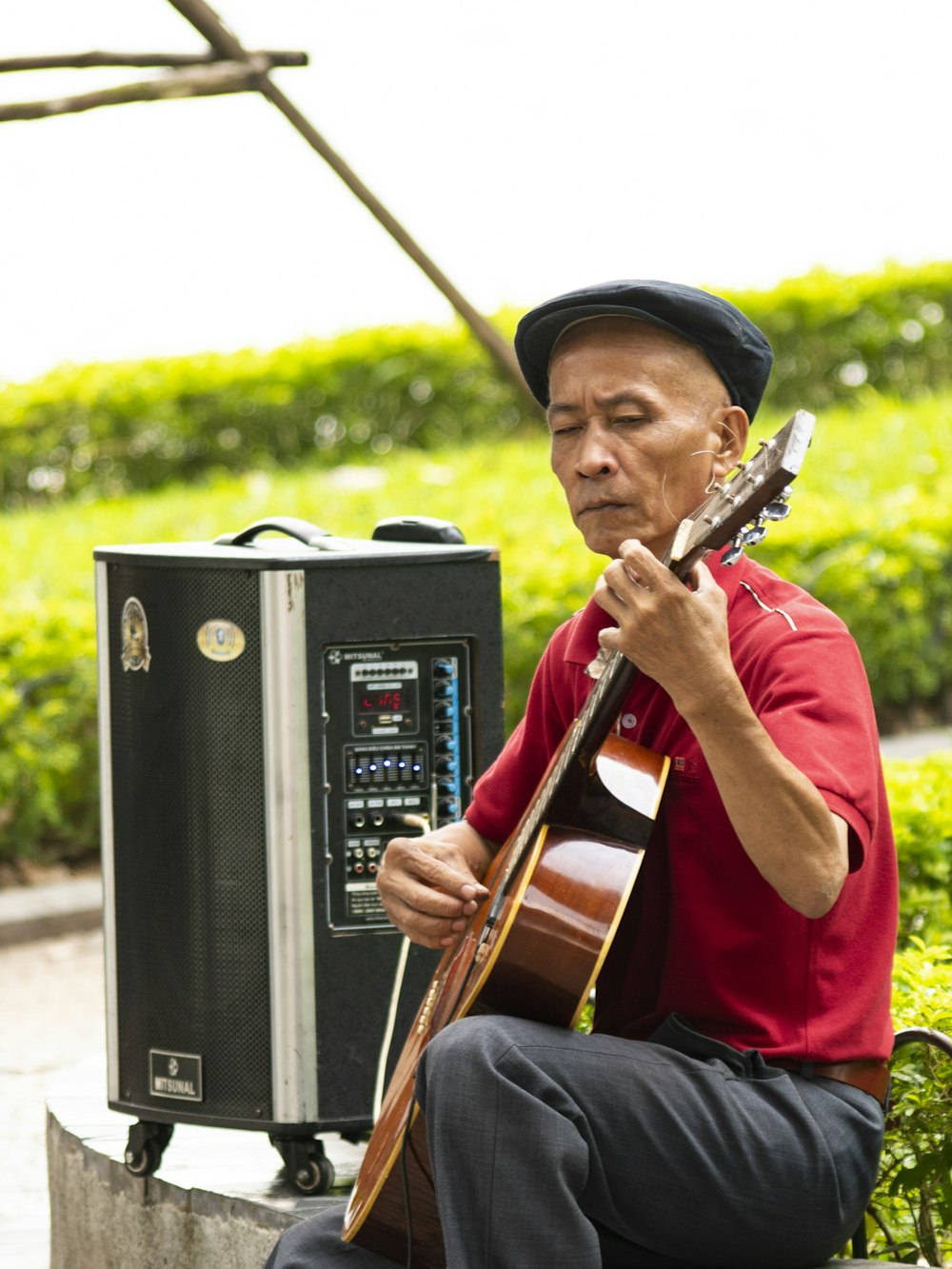 man in red shirt playing guitar