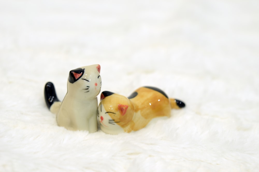 estatuetas de gato de cerâmica branca e preta