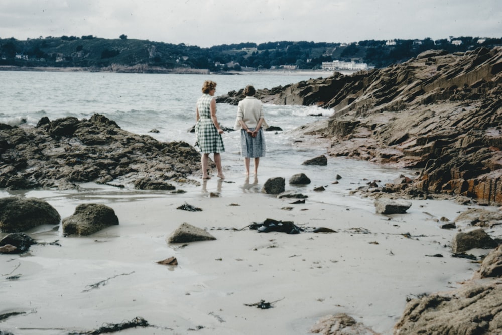 man and woman walking on beach during daytime