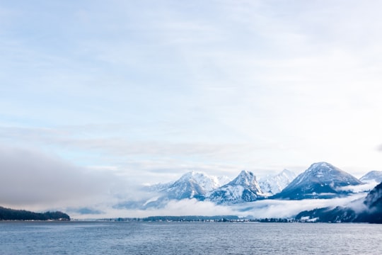 snow covered mountain near body of water during daytime in Sankt Gilgen Austria