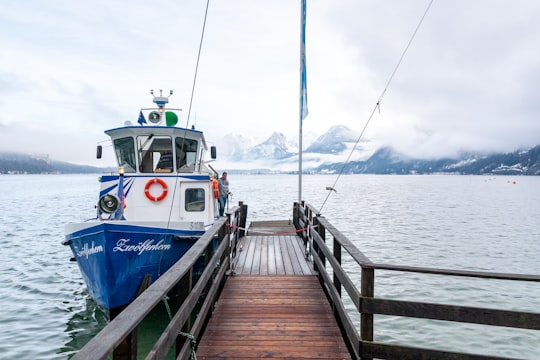 white and blue boat on sea dock during daytime in Sankt Gilgen Austria