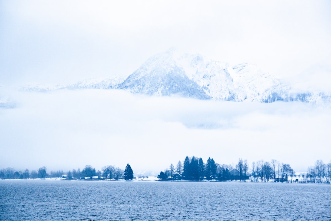 snow covered mountain near body of water during daytime