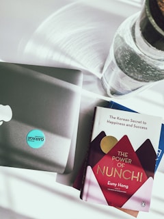 A sleek, dark blue book cover of 'The AI-Powered CEO' resting on a polished wooden desk beside a golden pen and a laptop.